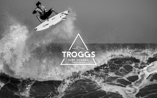 Troggs Surf School logo on a photography of a surfer surfing.